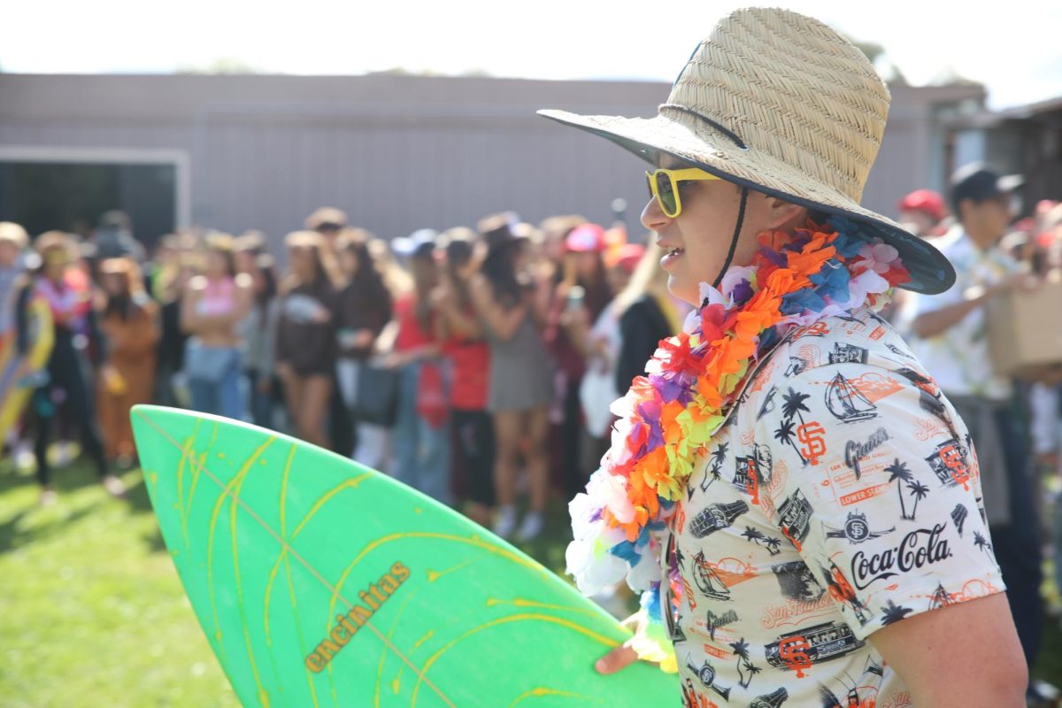 Junior Eli Kozodoy holds his surfboard and gets ready to show off his outfit.