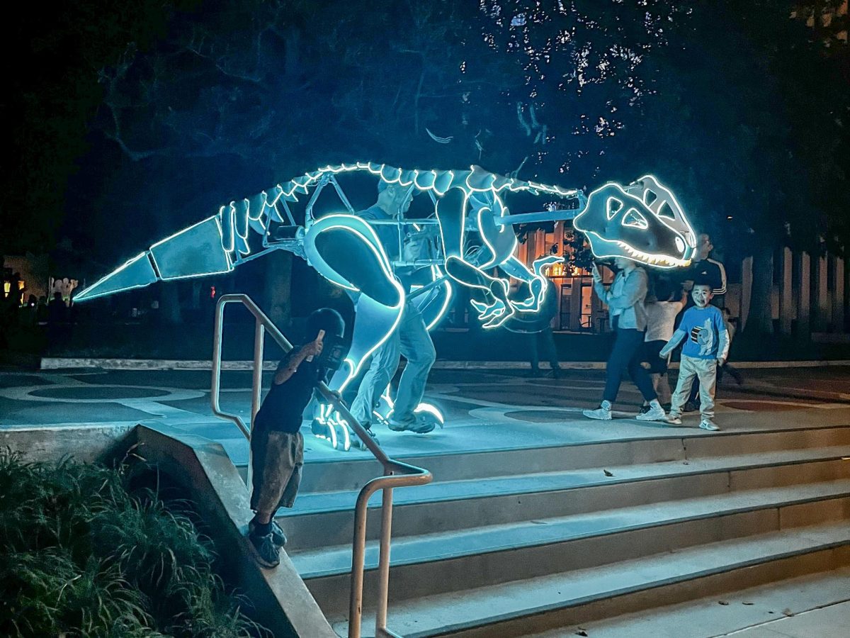 Children stare in awe at the life-sized dinosaur suit walking around on Saturday during Code:Art Festival in downtown Palo Alto. According to Palo Alto High School sophomore attendee Saurya Thummalapalli, the lit-up dinosaur left the greatest impression on him out of all the exhibits. “The dinosaur was pretty interesting just because the guy who was manning it was really interactive,” Thummalapalli said. “I was with some family friends, and there was a baby — she was only in second grade — so she was having a lot of fun with the dinosaur guy and interacting a lot. That one was definitely the most memorable one.”