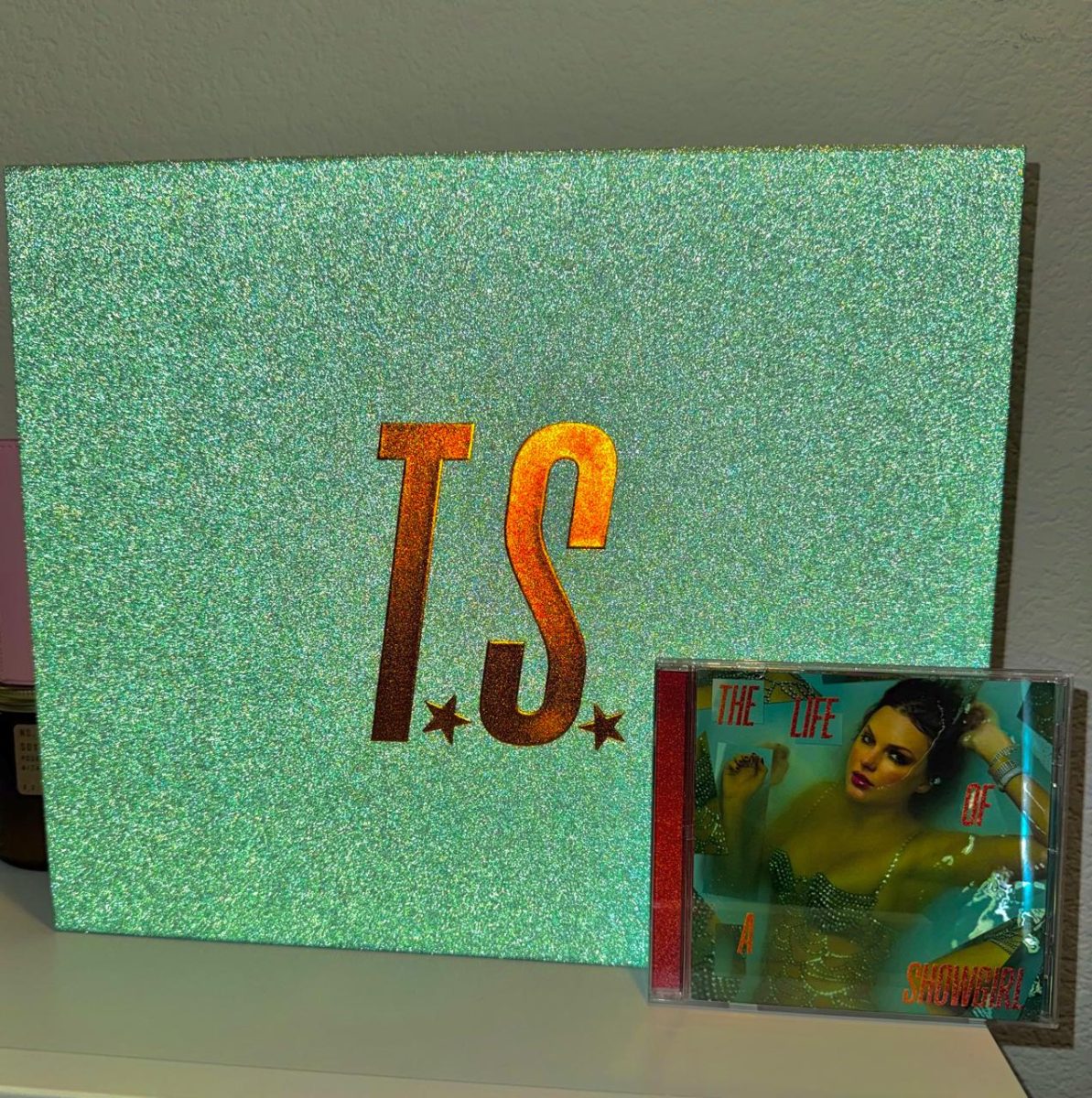 Taylor Swift's newly released album, "The Life of a Showgirl," comes with glamorous merch, like this sparkly box containing the album's CD and more. Fans like Fione O'Neill especially enjoy Swift's collaboration with popular artist Sabrina Carpenter. "My favorite song is probably the title track with Sabrina Carpenter because their vocals sounded so good together. I especially like the upbeat chorus," O'Neill said.