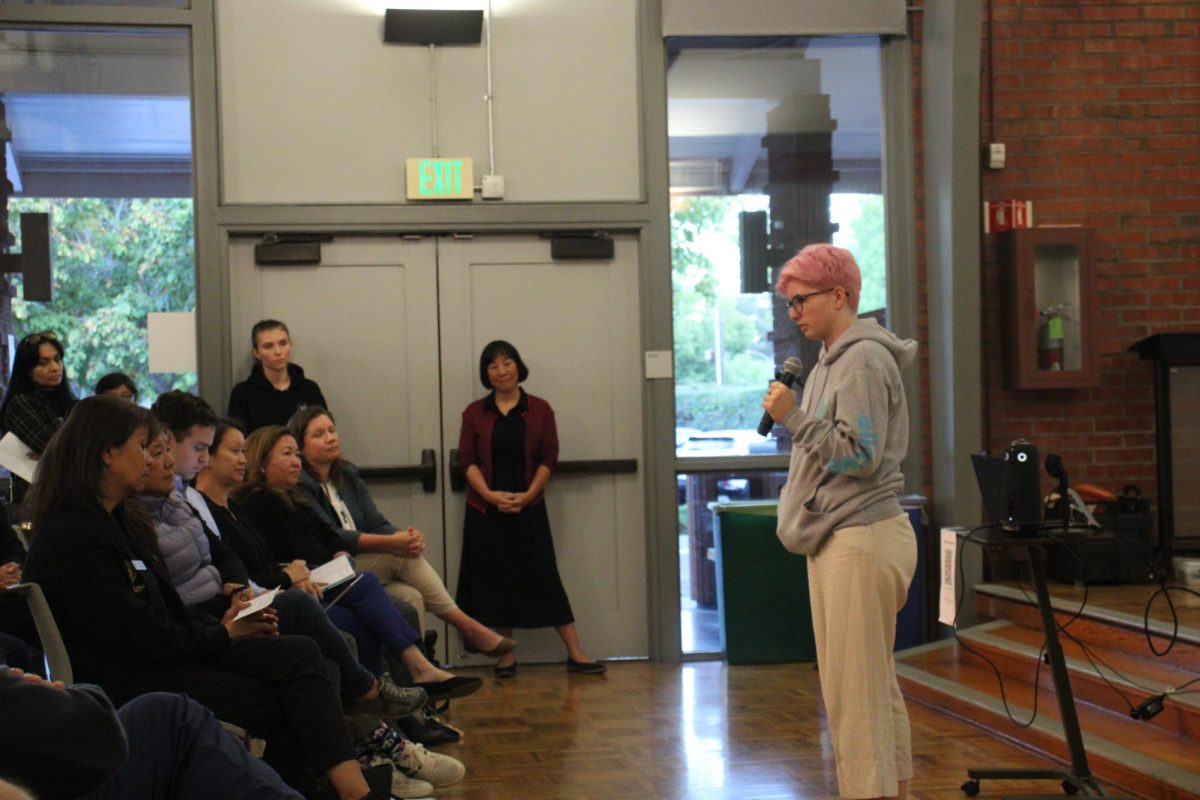 Palo Alto High School alumnus Tess Manjarrez speaks to the crowd last Tuesday at The Palo Alto Art Center during the Youth Mental Health & Allcove Community Meeting as Santa Clara County District supervisor Margaret Abe-Koga looks on from the front row. Manjarrez said Allcove plays a critical role in supporting students with mental health needs in the community. “I don’t think there was anyone at Paly or Gunn that was more than 2 degrees separated from someone who took their own life,” Manjarrez said. “It’s part of the culture. It twists you.”