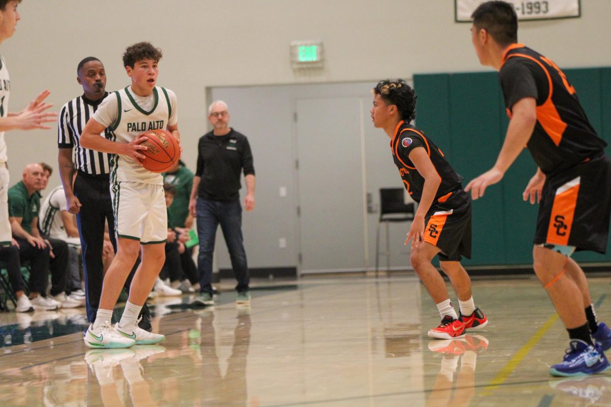 Viking freshman Gabe Andrade surveys the floor while facing tight pressure from two defenders during Saturday's home game against Silver Creek High School. According to Andrade, these moments are when the team's practice shows. "When the defense closes in, we rely on our composure," Andrade said. "Staying calm lets us make the best decisions and that's what keeps us in control of the game."