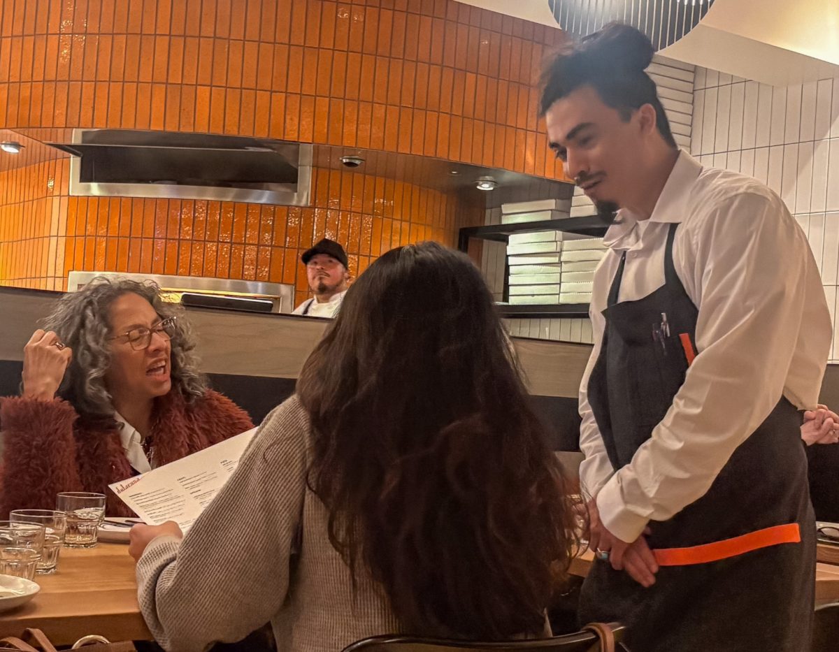Server Randy Rodriguez takes orders from a family dining Sunday at Delarosa, Stanford Shopping Center’s newest restaurant. According to Rodriguez, challenges have been fitting in with the other shops at Stanford. “Settling in with the clientele here has been something to focus on and providing upscale service compared to other chains or restaurants that are already existing here," Rodriguez said.