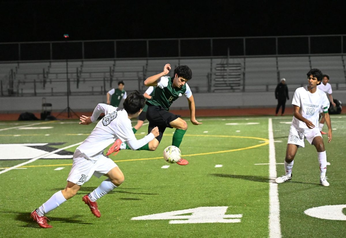 Viking Senior forward Santiago Sanchez dribbles past Mustang defenders in the game against the Homestead High School Friday night at home. According to Sanchez, playing his last game in the Paly stadium was an emotional experience. "It’s the last game I’ll play here at Paly," Sanchez said. "I’ve played since freshman year and it’s just a lot of mixed emotions. Sadly we didn’t win the tie, but it was a good game overall. I’m pretty proud of this team."