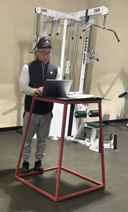 Physical education teacher Jason Fung works on his computer during his weightlifting class on Thursday at Palo Alto High School. According to Jason Fung, he is very grateful for Paly’s community and the support he received. “I was very blessed for the support I got in this community and from a lot of the students,” Jason Fung said.