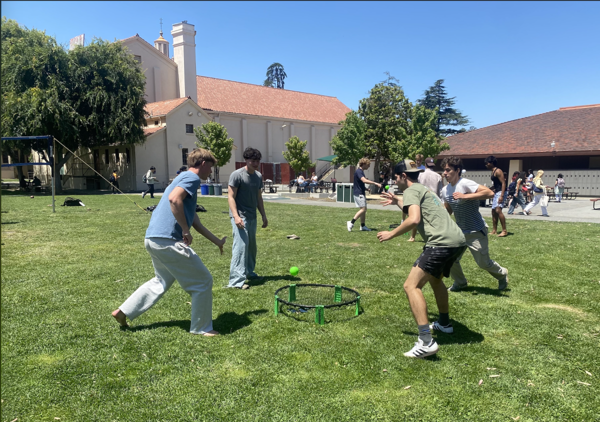 Senior Max Mommessin prepares to hit a spikeball during Paly Play Day on Friday at Palo Alto High School. According to senior Ethan Kleiner, Paly Play Day was a great way to spend time before graduation. "It was a lot of fun playing cornhole out on the quad with my friends," Kleiner said. "The music and everyone out in the sun made it a really nice vibe to end the year."